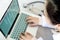 Top view,female doctor working on desk with laptop computer and stethoscope,closeup health professional using a laptop with