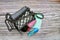 Top view of female fashion accessories . Metallic gray handbag with compact powder, lipstick ,wallet ,Alcohol bottles and mask.