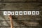 Top view of female hand arranging nine white cards with letters