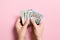 Top view of female hand holding a pack of money on colorful background. Various dollars. Business concept. Charity and tips