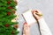 Top view of female hand writing in a notebook on cement Christmas background. fir tree and festive decorations. Wish list. New