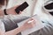 Top view of female hands holding smarthone and pen. Woman writing notes on notepad. Empty copy space on cellphone screen. Telework