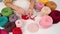 Top view of female hands with knitting on a white table. A woman knits a basket of red cotton yarn.