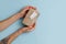 Top view of female hands placing cardboard box with a tag on a blue surface