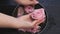 Top view female hands using hand skin care bath , bowl with pink roses and rose oil for skin and nails care