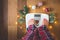 Top view of female legs in pajamas on a white weight scale with Christmas decorations and lights on wooden background