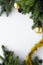 Top view on festive decorations such as gold baubles, tinsel, conifer branches and cones. Christmas vertical greeting card with