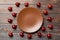 Top view of festive plate with red baubles on wooden background. Christmas decorations and toys. New Year advent concept