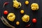 Top view fettuccine with yellow and red tomatoes, chili, sprig of thyme on background of black spaghetti with cuttlefish ink
