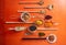 Top view of fflat lay of assortment of legumes on orange tabletop background, in scoop and ladles.