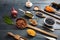 Top view of flat lay of assortment of legumes on black wooden tabletop background, in scoop and ladles and grater.