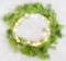 Top view flat lay blurred green Christmas wreath with lights on bright backgrou