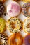 Top view flat lay of a colorful group of twelve delicious donuts in a white paper box on a wooden table. Collection of dozen