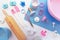 Top view flat lay with cute pink and blue baking utensils like baking mat, wooden rolling pin, mixing bowls and cookie cutters