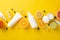 Top view flat lay of mockup cream bottles, jars, serum, pipette with orange grapefruit lemon lime in line yellow background