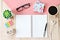 Top view or flat lay of open notebook paper, accessories, cube calendar and coffee cup on wooden background