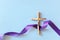 Top view flat lay of wooden cross crucifix with violet purple ribbon cloth with copy space. Holy week, lent season, Catholicism.