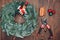 Top view florist making Christmas wreath on wooden table, flat lay tree branches secateurs, deer with red scarf