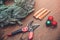 Top view florist making Christmas wreath on wooden table, flat lay tree branches secateurs, deer with red scarf