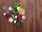 Top view of a flowers bouquet with roses, calla lilies, daisies and carnations, on a wooden floor , selective focus on the bouquet