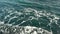 Top view of the foamy waves of the sea near the cliffs. Dark blue sea. Slow motion.