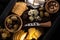 Top view of food composition of cheese, dried olives, fruits, pistachios and crackers on wooden tray.