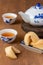 Top view of fortune cookies on a plate, teapot and Chinese cups with tea, on wooden table, with selective focus,