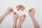 Top view four child hand with many walnuts  on white background,