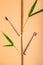 Top view fresh bamboo cane with green leaves and toothbrushes in form of bamboo plant on beige background. Concept of