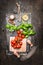 Top view of fresh cherry tomatoes with basil and olive oil on rustic background