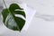 Top view of fresh clean towels and tropical leaf on the white bathroom shelf.Empty space for text