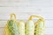 Top view of fresh courgettes in row bag over white rustic background