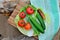 Top view of fresh cucumbers, tomatoes, Chinese cabbage, green onions and charcoal grilled sausages lying on a plate