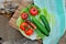 Top view of fresh cucumbers, tomatoes, Chinese cabbage, green onions and grilled sausage lying on a plate