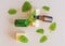 Top view of fresh green mint or spearmint leaves and glass dropper bottles of mint essential oil on gray background. Natural