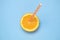 Top view of fresh orange fruit slice with drinking straw isolated on blue