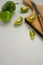 Top view of fresh ripe green garden tomatoes, cutting board and a knife on white background
