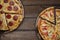 Top view of fresh tasty pizzas on rustic wooden background