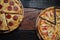 Top view of fresh tasty pizzas on wooden background