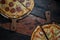 Top view of fresh tasty pizzas on wooden background