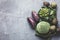 Top view on fresh vegetables arranged around border on grey kitchen countertop..