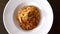 Top view of freshly cooked spaghetti bolognese on white plate on black table