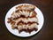 Top view of fried pork crackling in white plate on wooden table