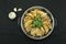 Top view of fried pot stickers, dumplings, and celery in a pan, black background