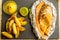 Top view of fried potatoes and baked fish in foil