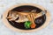 Top view of Fried snapper with radish, carrot, shiitake and choy sum in hot plate on wooden plate on washi Japanese paper