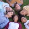 Top view, friends and group relax on grass at park on vacation, holiday or summer travel. Above, people smile and