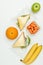 top view of fruits and sandwiches in ziplock bags isolated on white