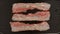 TOP VIEW: Frying a strips af bacon on a black pan