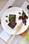 Top view of Fudge Brownie with Fresh Plum on Plate with Wooden Fork